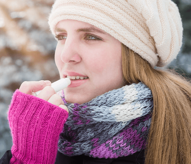 woman putting on chapstick