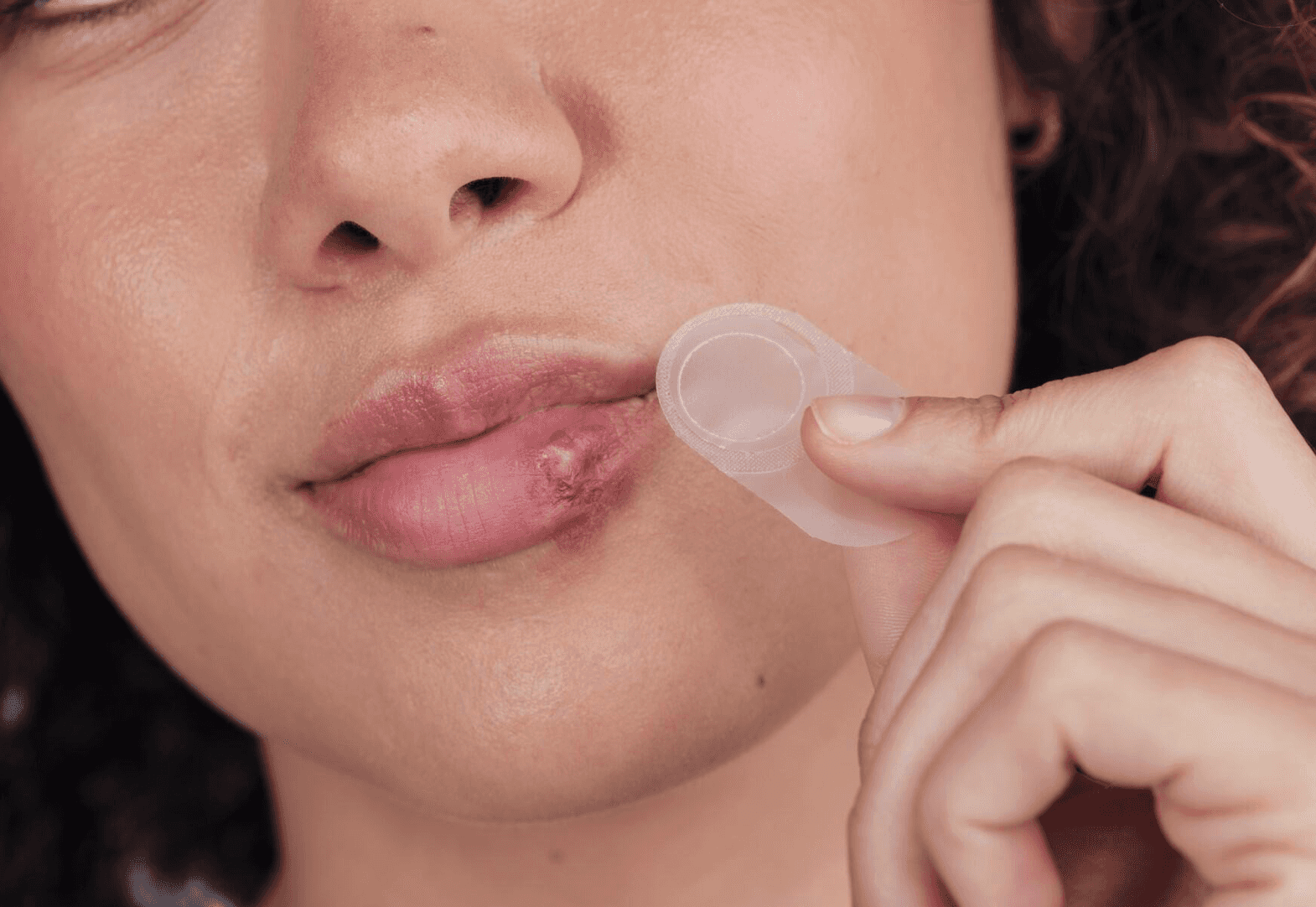 Woman putting Compeed Herpes Patch on the Cold Sore on her lip